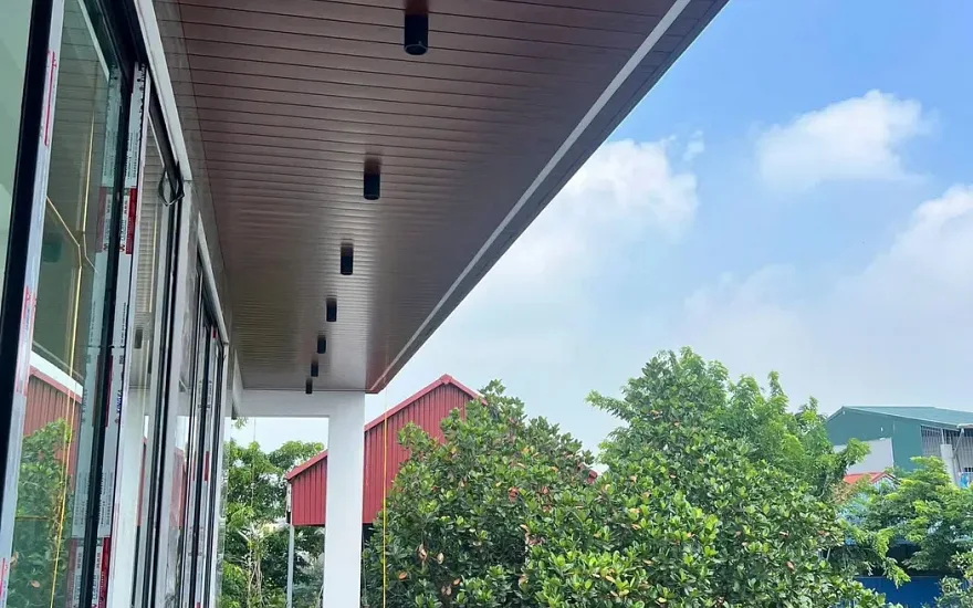 Hành lang ngoài trời ốp trần nhôm vân gỗ nhìn ra cây xanh